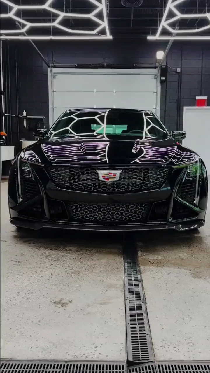 Black Cadillac CT5 detailed under the hexagonal LED ceiling of our Danbury, CT studio